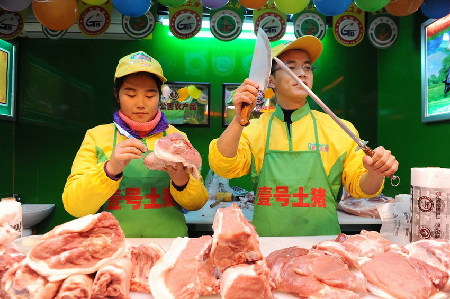 　2013年1月29日，上海天山路585弄澳華菜市場(chǎng)，江西財(cái)經(jīng)大學(xué)本科畢業(yè)生郝承兵（右）與海南大學(xué)本科生孫夏（左）在“壹號(hào)土豬”柜臺(tái)上工作。 