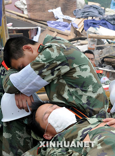 5月17日，救援人員在四川省什邡市救災(zāi)現(xiàn)場抓緊時(shí)間小憩。 汶川地震發(fā)生后，救援人員奔赴各個(gè)災(zāi)區(qū)，爭分奪秒、夜以繼日地在搜救現(xiàn)場奮戰(zhàn)。為了盡量多地救出掩埋在廢墟下的生還者，他們與時(shí)間賽跑，利用有限的空閑稍事休息，補(bǔ)充體力。