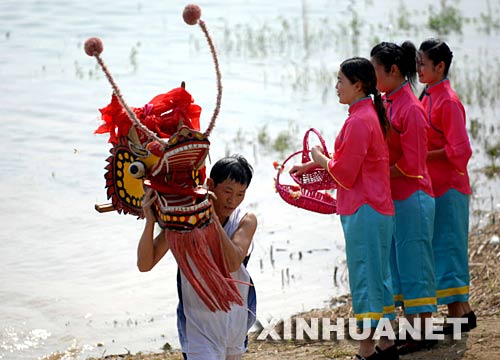 6月2日，一名龍舟隊員正在汨羅江邊祭龍頭。 當日，“我們的節(jié)日·端午節(jié)”主題文化活動暨第三屆中國汨羅江國際龍舟邀請賽在湖南汨羅市舉行。來自澳大利亞、荷蘭以及中國各地的十幾支龍舟隊在汨羅江參加角逐。汨羅是中國古代偉大詩人屈原晚年生活、創(chuàng)作和投江殉國之地。 新華社記者 李尕 攝 