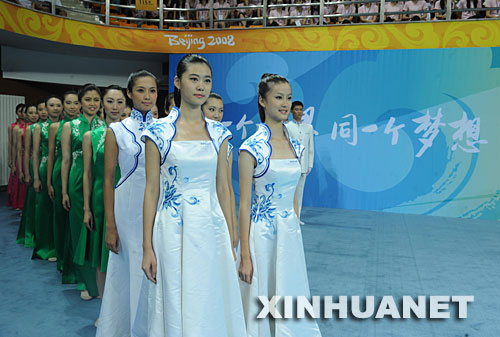 7月20日，志愿者們準(zhǔn)備進(jìn)行頒獎(jiǎng)儀式服裝展示。當(dāng)日，北京奧運(yùn)會(huì)、殘奧會(huì)體育展示與頒獎(jiǎng)儀式工作匯報(bào)暨誓師動(dòng)員大會(huì)在北京理工大學(xué)體育館舉行，集中匯報(bào)展示了北京奧運(yùn)會(huì)、殘奧會(huì)頒獎(jiǎng)儀式服裝及頒獎(jiǎng)儀式標(biāo)準(zhǔn)流程、競技拉拉操表演、民族民間舞蹈表演和吉祥物表演等項(xiàng)目。 新華社記者羅曉光攝 