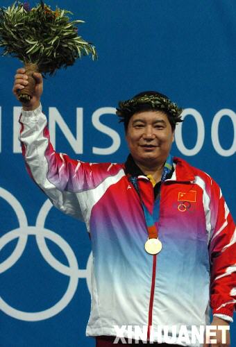 2004年8月14日，王義夫獲第28屆雅典奧運(yùn)會射擊男子10米氣手槍金牌。圖為王義夫在領(lǐng)獎臺上向觀眾致意。 