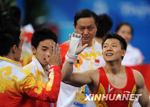  8月9日，中國選手陳一冰（右）在完成他的吊環(huán)動(dòng)作后和隊(duì)友楊威擊掌致意。陳一冰的吊環(huán)資格賽成績?yōu)?6.525分。當(dāng)日，中國隊(duì)在北京奧運(yùn)會(huì)體操男子資格賽第二場的比賽中，以374.675分的總成績暫列資格賽第一。