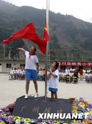 8月27日，映秀小學(xué)學(xué)生在板房校園內(nèi)升起鮮艷的五星紅旗。 新華社發(fā)